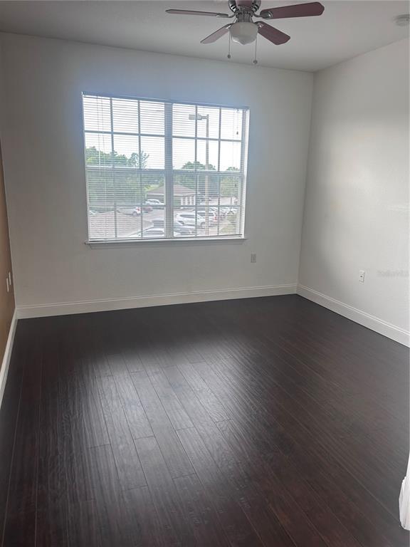 8213 Claire Ann Drive, Unit 203 Orlando, FL 32825 - Photo 5 of 9 wooden floor in an empty room with a window