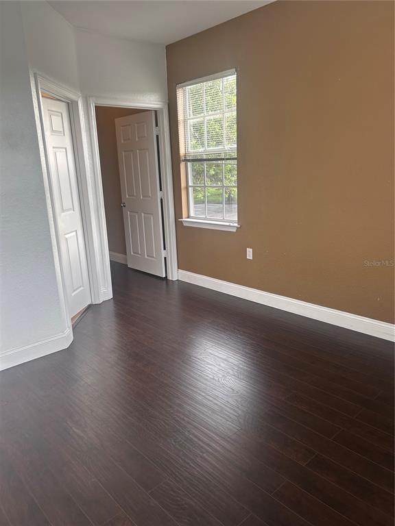 8213 Claire Ann Drive, Unit 203 Orlando, FL 32825 - Photo 7 of 9 an empty room with wooden floor and windows