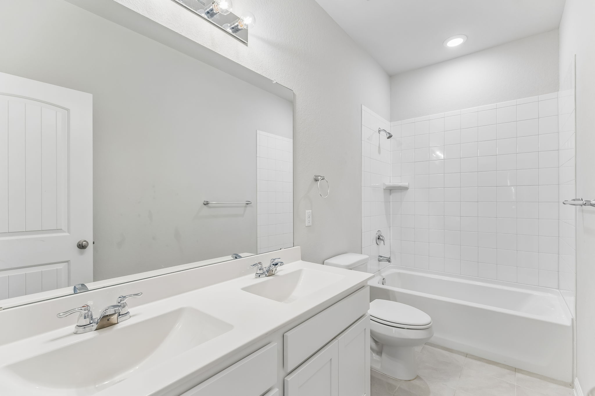 4009 Milano River Road Hutto, TX 78634 - Photo 30 of 40 A classic tiled tub shower anchors this well-appointed bathroom with a spacious dual vanity.
