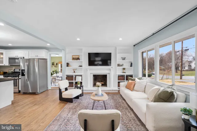a living room with furniture a fireplace a flat screen tv and a large window