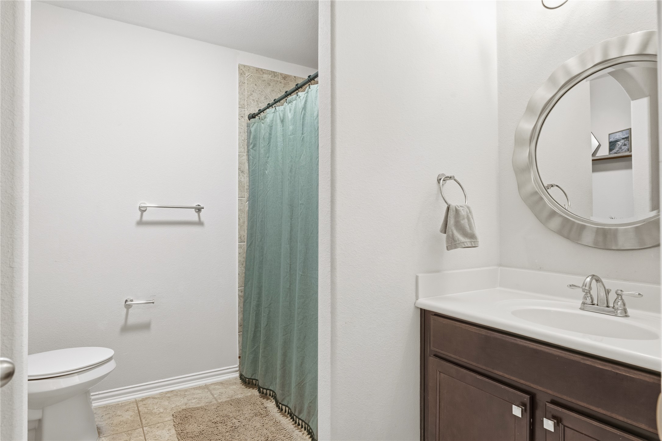 486 Pond View Pass Buda, TX 78610 - Photo 24 of 39 Bathroom featuring a vanity with a white countertop, chrome fixtures, and a circular framed mirror