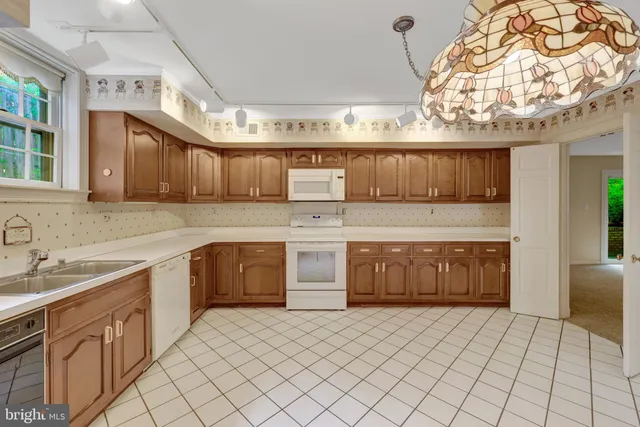 a kitchen with stainless steel appliances granite countertop a sink refrigerator and cabinets