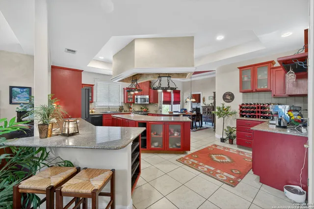 a kitchen with stainless steel appliances kitchen island granite countertop a table chairs in it and wooden floors
