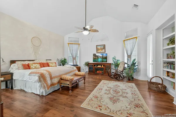 a bedroom with bed a couch and potted plant on the dresser