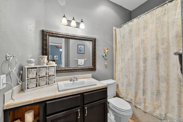 a bathroom with a sink a toilet and a mirror