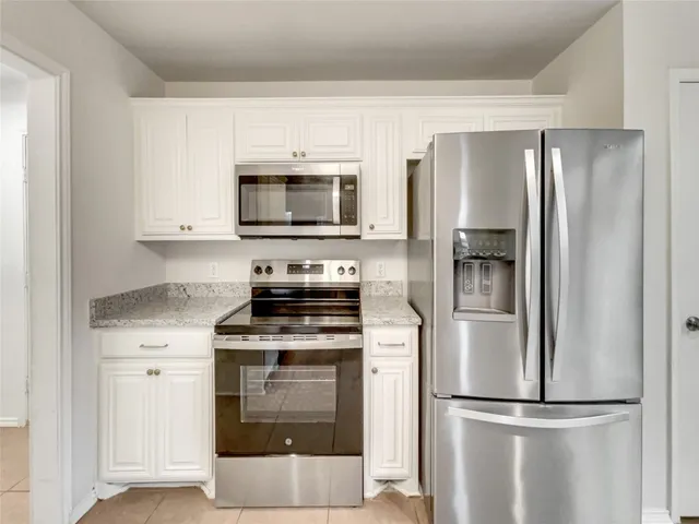 a kitchen with cabinets stainless steel appliances and a counter top space