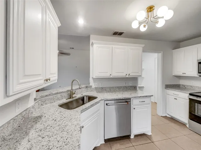a kitchen with white cabinets appliances and sink