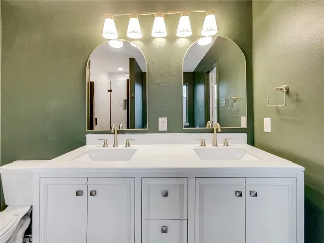 a bathroom with a double vanity sink and a mirror