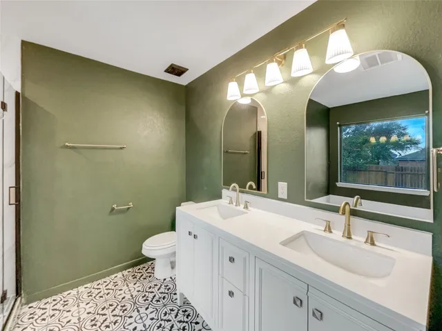 a bathroom with a sink a toilet and a mirror