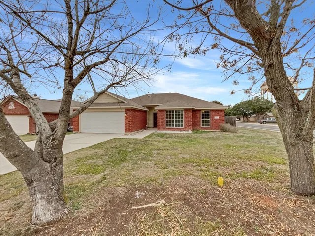 a view of a yard in front of a house with large trees