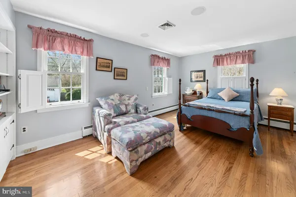 a living room with furniture a large window and wooden floor