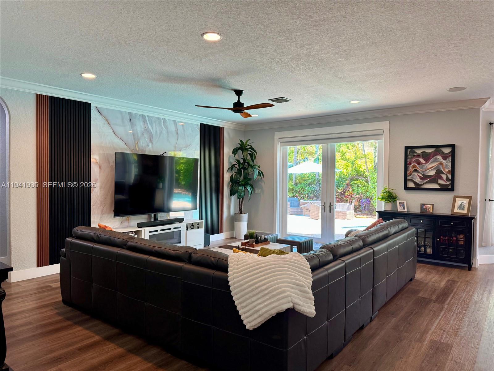 a living room with furniture flat screen tv and a large window