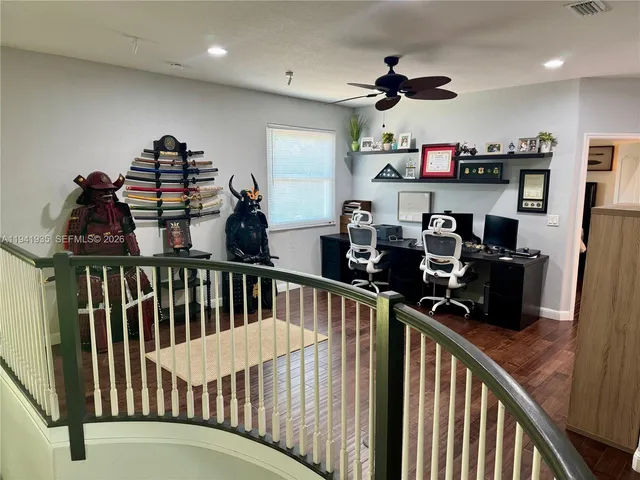 a view of a hallway with workspace and a window