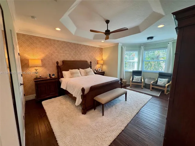 a bedroom with a bed a couch and a large window