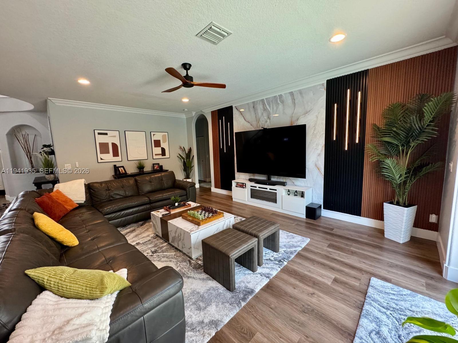 12917 Southwest 23rd Street Miramar, FL 33027 - Photo 2 of 47 a living room with furniture and a flat screen tv