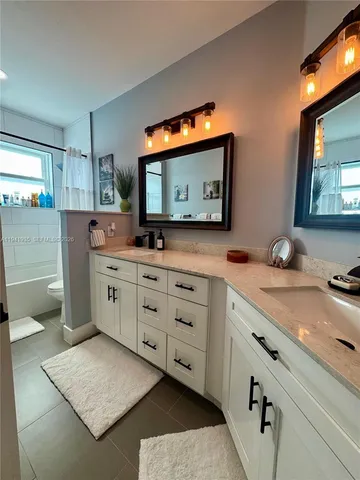 a bathroom with a sink a large mirror and a toilet