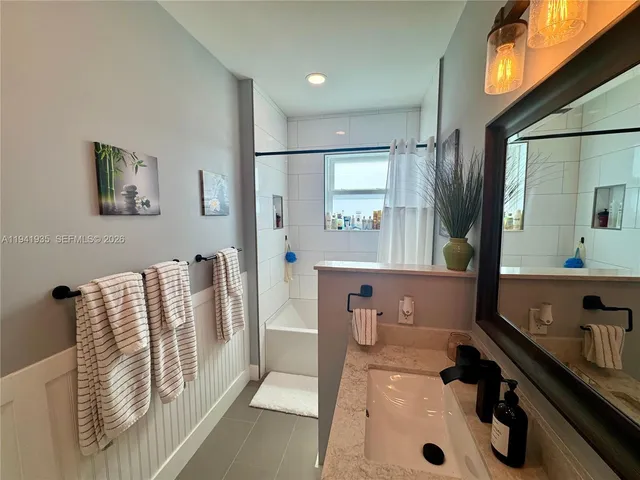 a bathroom with a tub sink and mirror