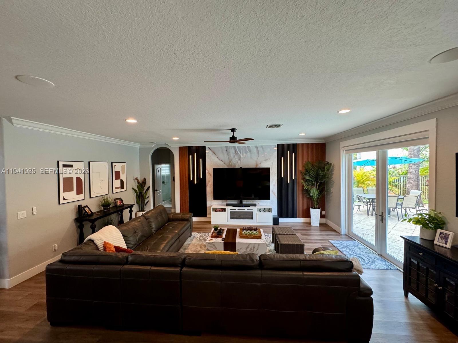 12917 Southwest 23rd Street Miramar, FL 33027 - Photo 3 of 47 a living room with furniture and a flat screen tv