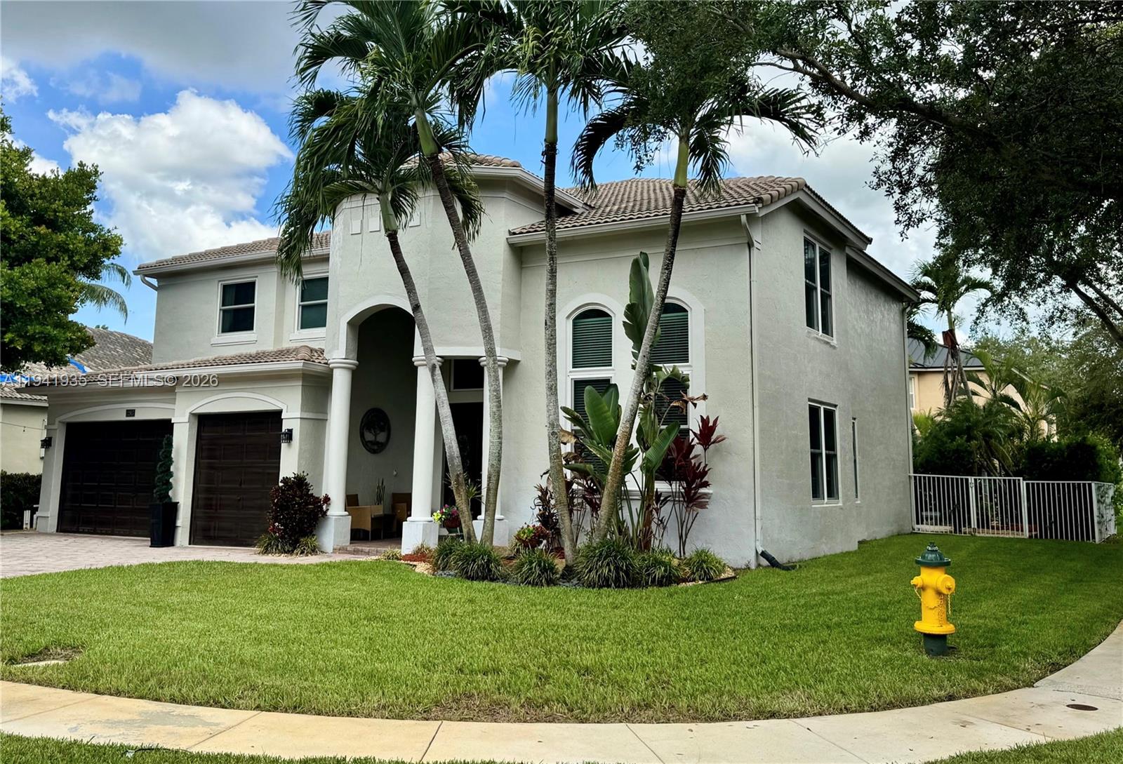 12917 Southwest 23rd Street Miramar, FL 33027 - Photo 46 of 47 a view of a white house with a big yard and potted plants and a large tree