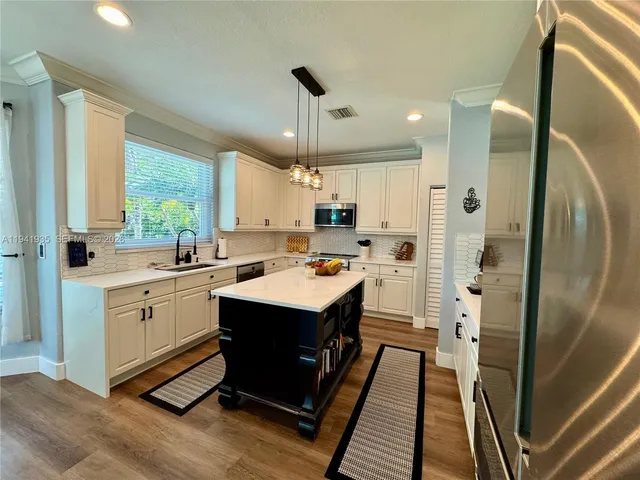 a kitchen with a sink stainless steel appliances and window