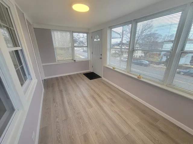 an empty room with wooden floor and fireplace