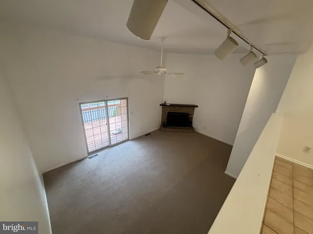 a view of a livingroom with an empty space and a window