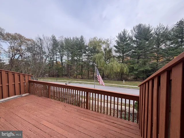 a balcony with wooden floor and trees in the background