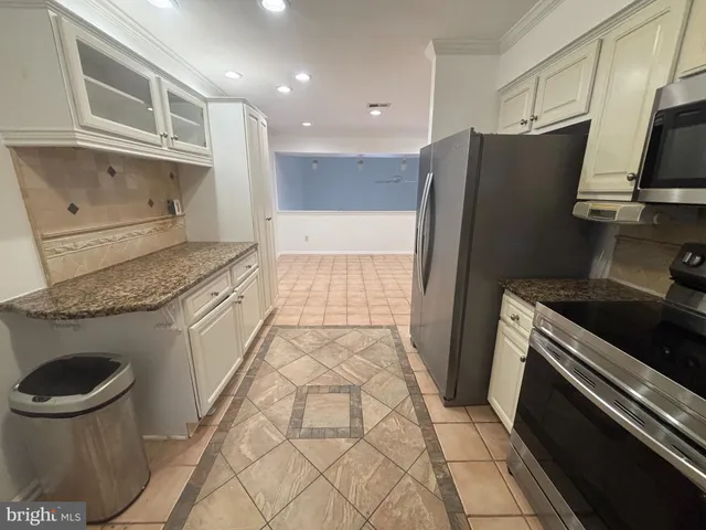 a kitchen with a sink a refrigerator and cabinets