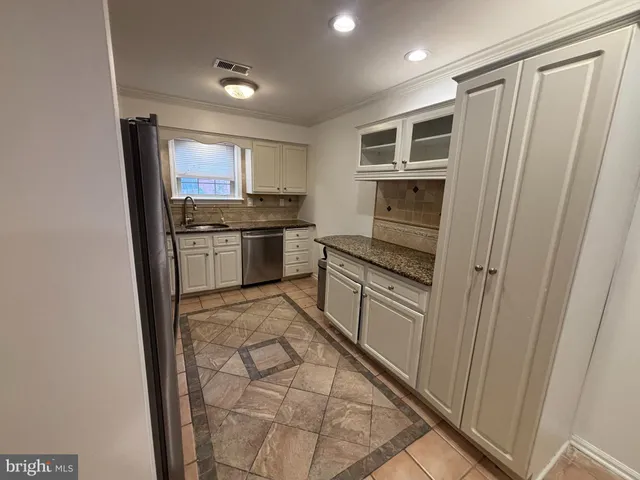 a kitchen with stainless steel appliances granite countertop a refrigerator and a stove top oven