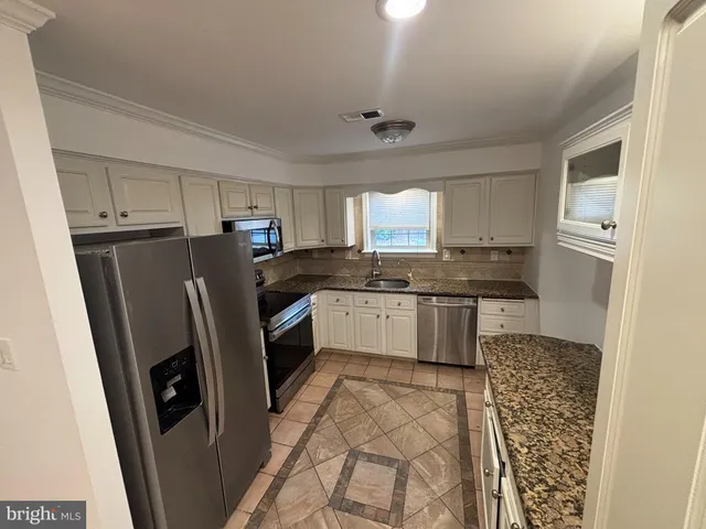 a kitchen with a refrigerator sink and cabinets