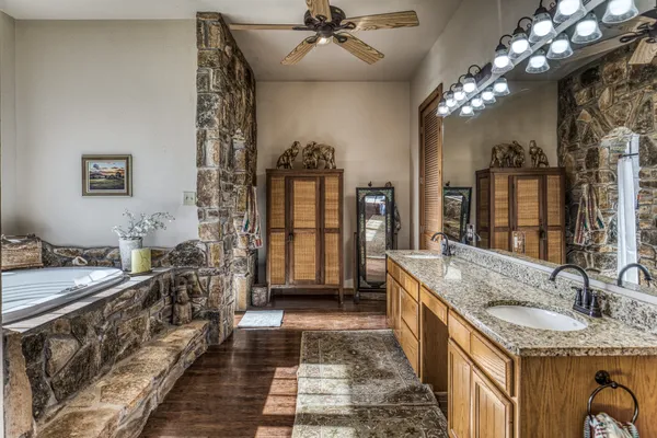 a spacious bathroom with a granite countertop sink a mirror and shower