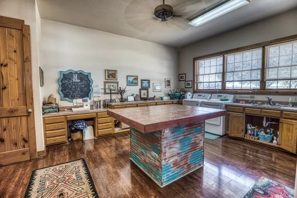 a open kitchen with stainless steel appliances granite countertop a stove refrigerator and a dining table with wooden floor