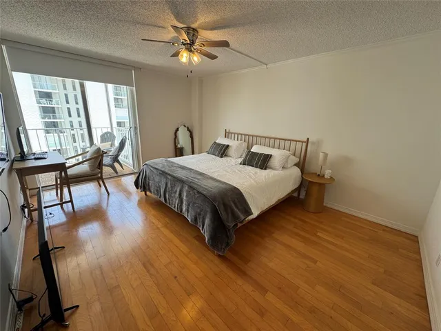 a bedroom with a bed a chandelier and next to a window