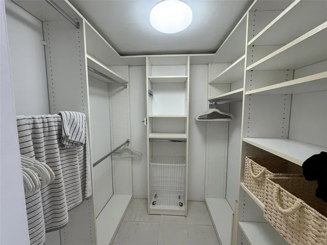 a bathroom with a walk in closet and wooden floor
