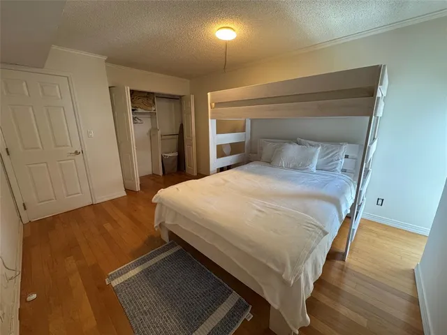 a bedroom with a bed and a lamp on dresser
