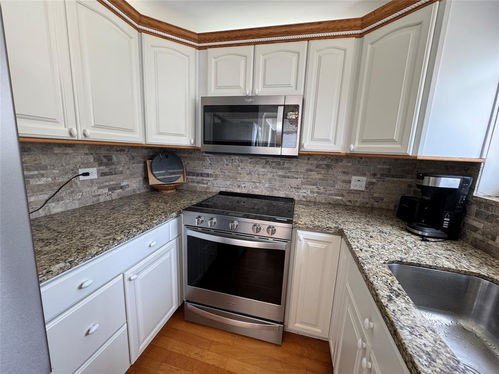 1010 South Ocean Boulevard, Unit 1612 Pompano Beach, FL 33062 - Photo 10 of 35 a kitchen with granite countertop a stove a sink and a microwave