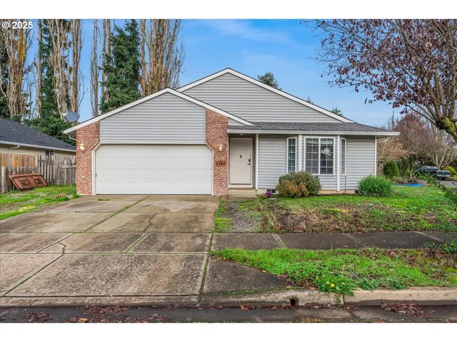a view of a yard in front of a house with large tree