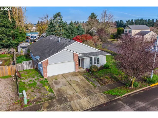 a aerial view of a house with a yard and table and chairs under an umbrella