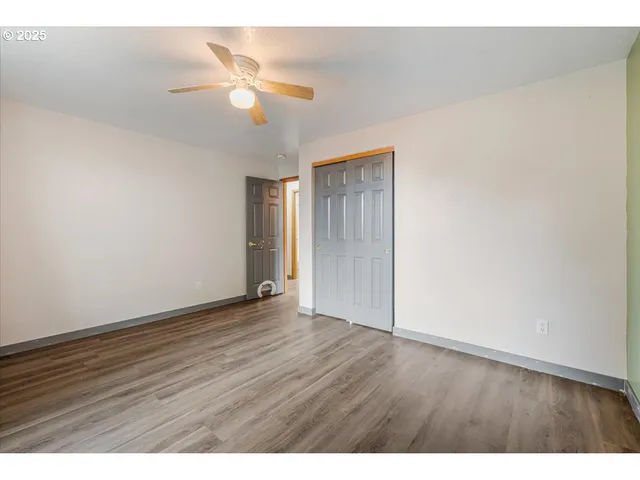 a view of an empty room with wooden floor