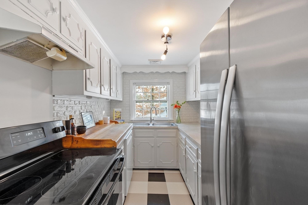 54 Birch Road Andover, MA 01810 - Photo 11 of 37 a kitchen with stainless steel appliances a refrigerator a sink a stove and white cabinets