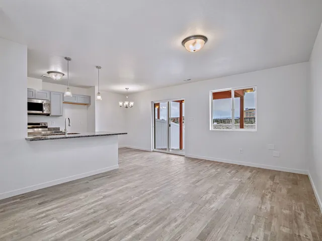 a view of a kitchen with kitchen island stainless steel appliances wooden floor and window