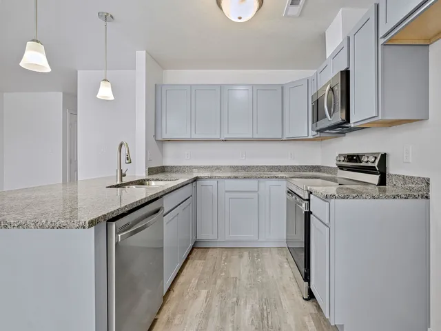 a kitchen with stainless steel appliances granite countertop a sink and stove top oven