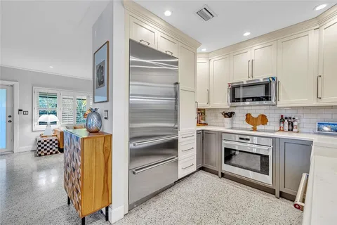 a kitchen with stainless steel appliances and white cabinets