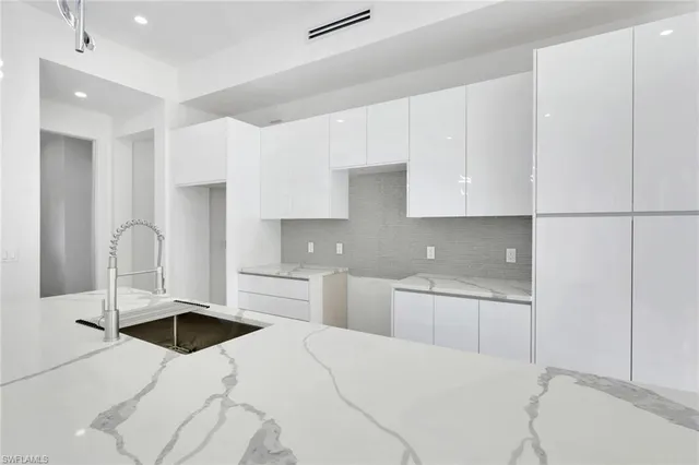 a kitchen with granite countertop a sink a stove and cabinets