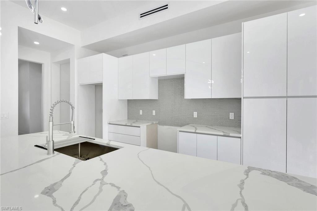3780 6th Avenue Southeast Naples, FL 34117 - Photo 11 of 33 a kitchen with granite countertop a sink a stove and cabinets
