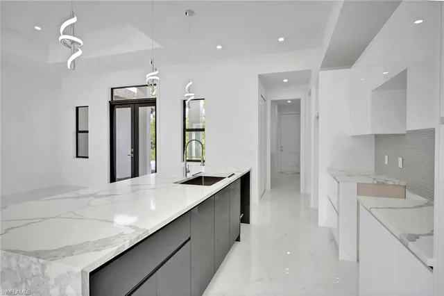 a kitchen with granite countertop a sink and white cabinets