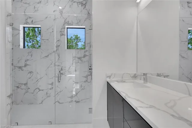 a bathroom with a granite countertop sink a vanity and window
