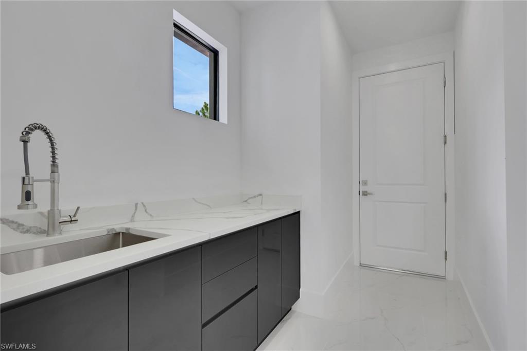3780 6th Avenue Southeast Naples, FL 34117 - Photo 29 of 33 a bathroom with a sink and a mirror