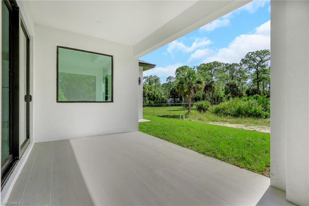 3780 6th Avenue Southeast Naples, FL 34117 - Photo 31 of 33 a view of a backyard with potted plants and floor to ceiling window