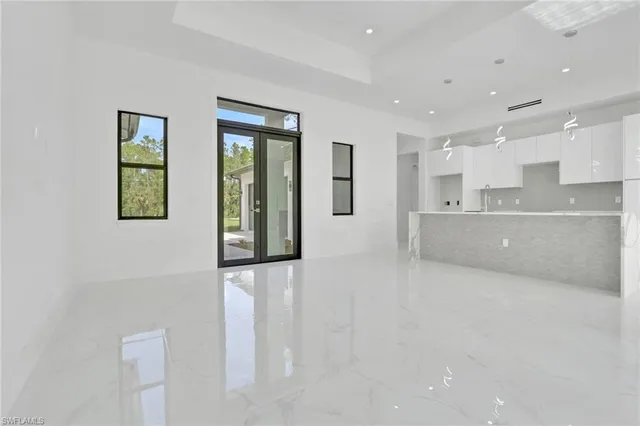 a large white kitchen with lots of counter space and windows